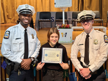 student holding plaque with two police officers